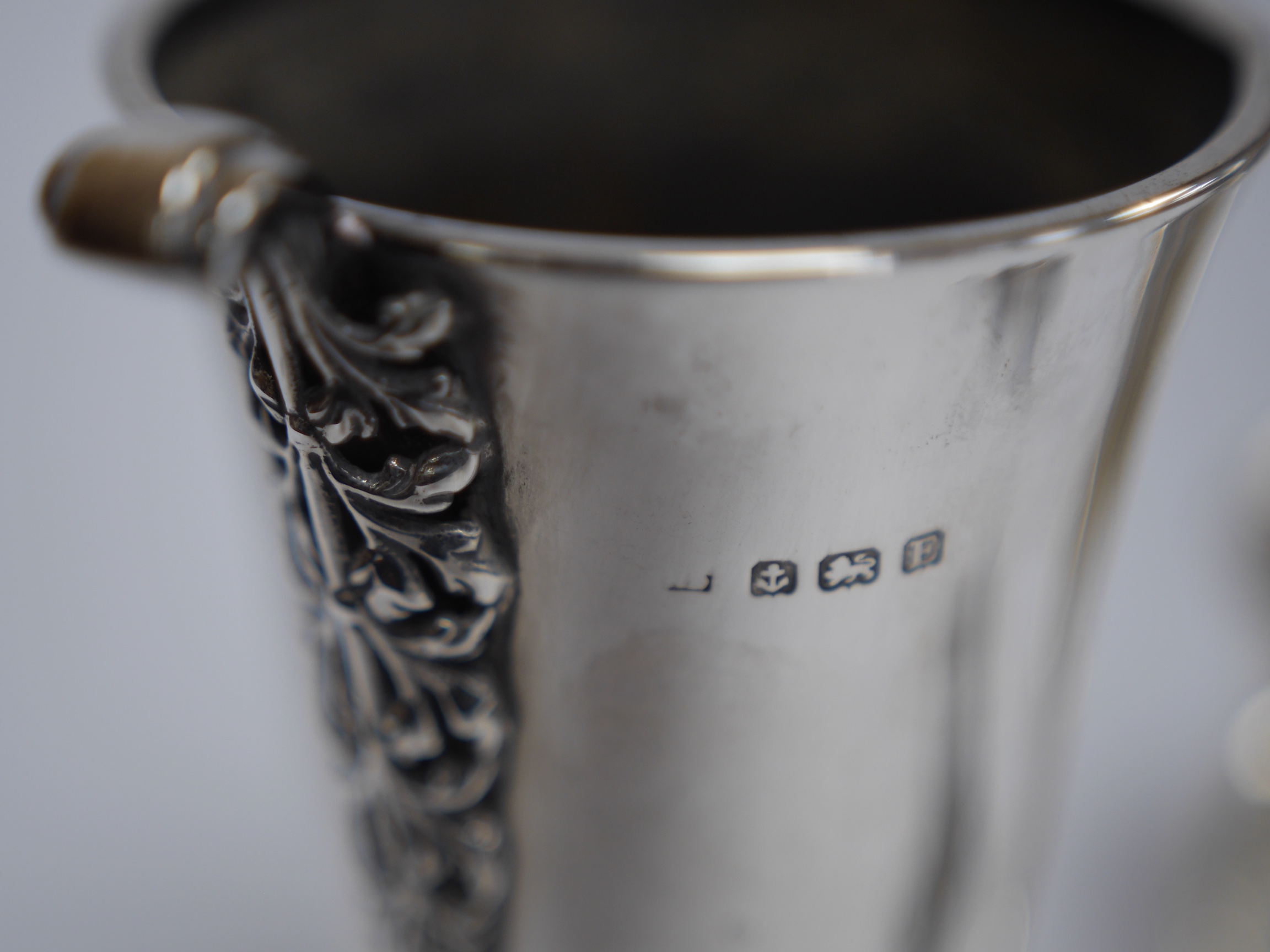 A George V silver spill vase, with pierced handles and stem, maker's mark rubbed, Birmingham, 1930, 16.6cm, together with a small silver tri-handled pedestal bowl, a small silver mug and Hanau white metal boat shaped sal